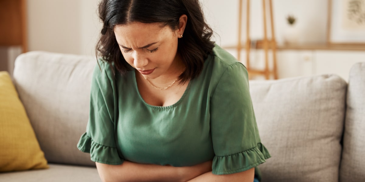 Femme souffrant de douleurs à l'estomac et de ballonnements abdominaux Femme souffrant de douleurs à l'estomac et de ballonnements abdominaux
