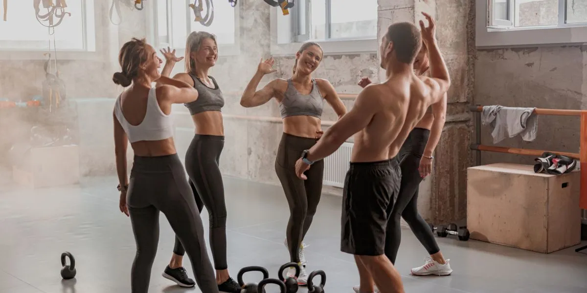 Équipe d'entraînement dans une salle de sport célébrant la fin d’une session