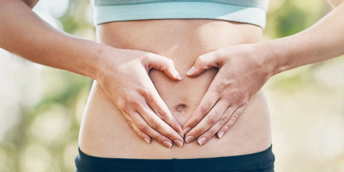 Mujer tocándose la barriga aliviada de dolor estomacal Mujer tocándose la barriga aliviada de dolor estomacal