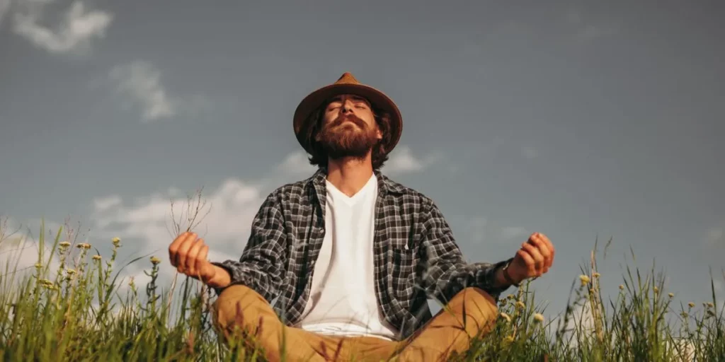 Homme méditant dans un champ