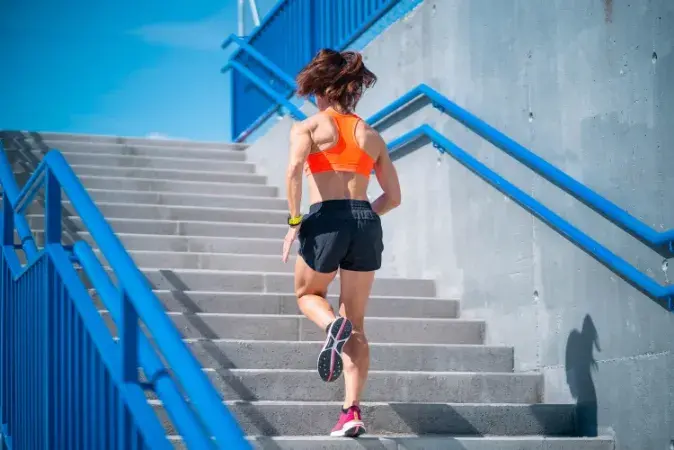 Femme montant les escaliers en courant