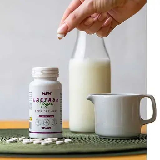 Tasse avec du lait au fond et les g&eacute;lules de lactase de HSN